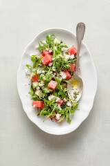 A light appetizer or an elegant side dish. Salad made with arugula, feta, pieces of watermelon and cucumber. Delicate flavor.