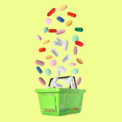 Fototapeta premium Different pills falling into shopping basket on pale yellow background