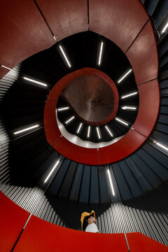 Fototapeta Dramatic Spiral Staircase with Concentric Red and Black Design Viewed from Below