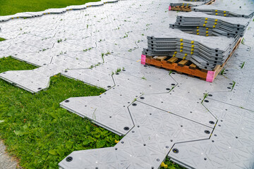 Installation of plastic portable floor to protect the lawn.