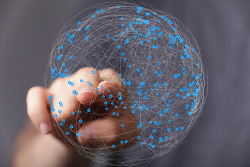 Abstract image of a hand interacting with a digital global network.  Represents connection,...