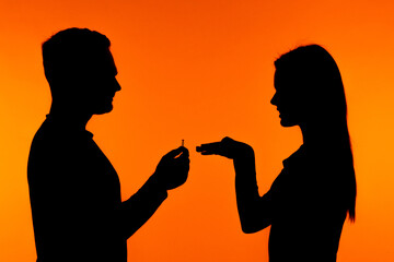 Silhouetted Proposal Scene Against Bright Orange Background