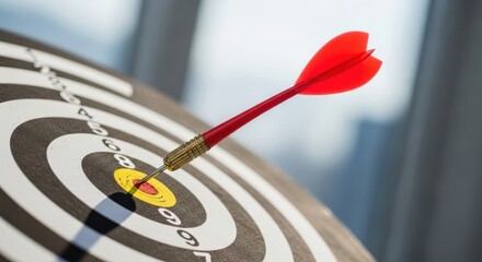 Red dart hitting the bullseye on a target board. Concept of achievement, goal setting, and success in business.