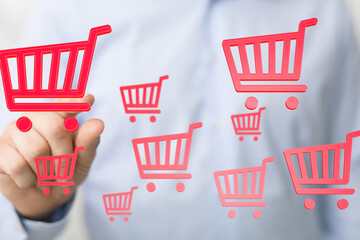 Person interacts with digital shopping carts, symbolizing online shopping growth and e-commerce.