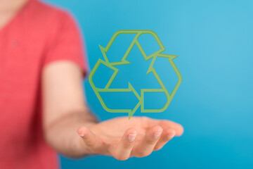 Image of a hand holding a green recycling symbol, representing sustainability and eco-consciousness.
