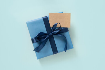 Happy Fathers Day gift box and blank on pastel blue background. Flat lay. View from above. Copy space.