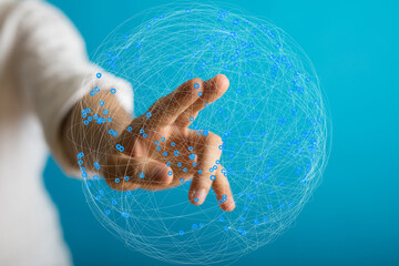 Abstract image of a hand interacting with a digital global network. Represents connection,...