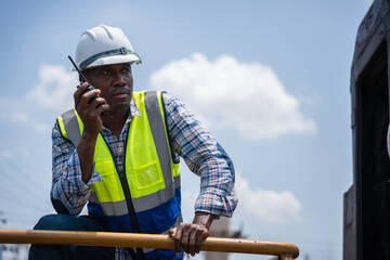 Engineer Inspecting Freight Train Cars and Cargo, Engineers Discussing Project Progress at Construction Site.