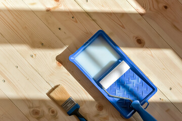 Paint tray with roller and brush on spotless wooden floor embodies preparation, attention to...