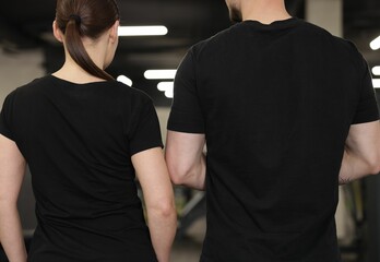 Personal trainers in sport center, back view