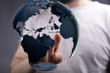 Person interacting with a 3D digital earth globe.  Global business, technology, and connection...