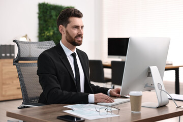 Man working on computer at table in office