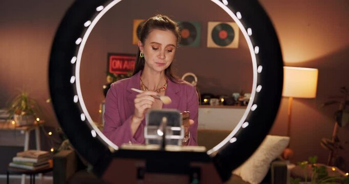 Makeup, live streaming and ring light with woman and phone for cosmetics promotion, brand and vlog. Beauty sponsorship, follower engagement and content creator with person in home as influencer