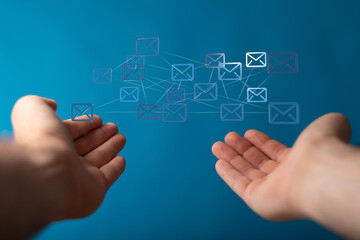 Image of connected email icons above open hands, representing global communication and networking.