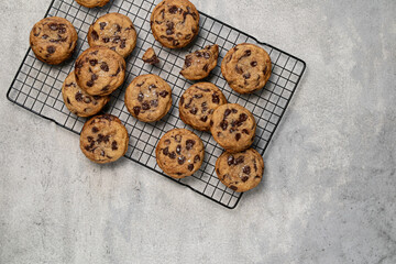 Homemade American brown butter chewy, fluffy and soft chocolate chip cookies on a cooling rack with salt. Biscuits for children. Top view, copy space.
