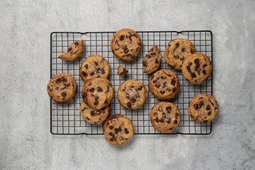 Homemade American brown butter chewy, fluffy and soft chocolate chip cookies on a cooling rack with salt. Biscuits for children. Top view, copy space.
