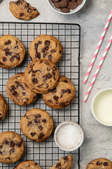 Homemade American brown butter chewy, fluffy and soft chocolate chip cookies on a cooling rack with salt and milk. Biscuits for children. Top view.