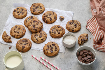 Homemade American brown butter chewy, fluffy and soft chocolate chip cookies on a baking parchment with salt and milk. Biscuits for children. Selective focus.