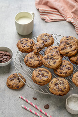 Homemade American brown butter chewy, fluffy and soft chocolate chip cookies on a cooling rack with salt and milk. Biscuits for children. Selective focus.