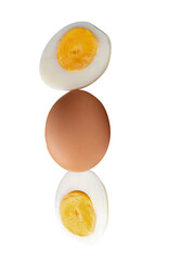 Top view of raw chicken egg and peeled cooked or boiled egg with egg yolk in two halves in stack isolated on white background with clipping path