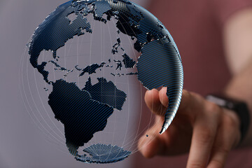 High-quality stock photo of a hand interacting with a 3D model of the Earth, symbolizing global...
