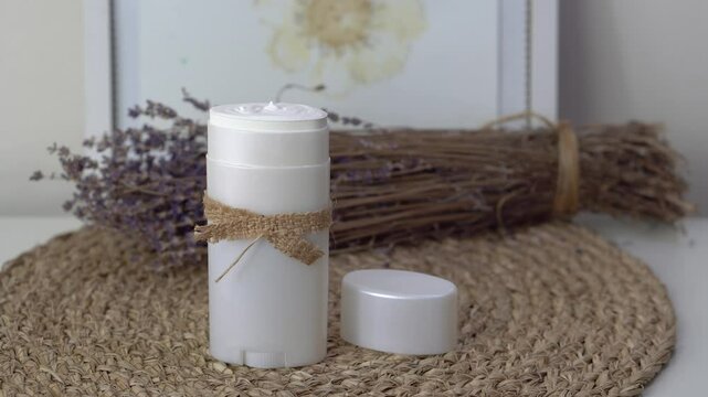 Homemade natural SPF stick with zinc oxide on white and beige background. Organic sun protection balm with dry lavender flower. Zero waste skincare. DIY sunscreen for summer skincare.