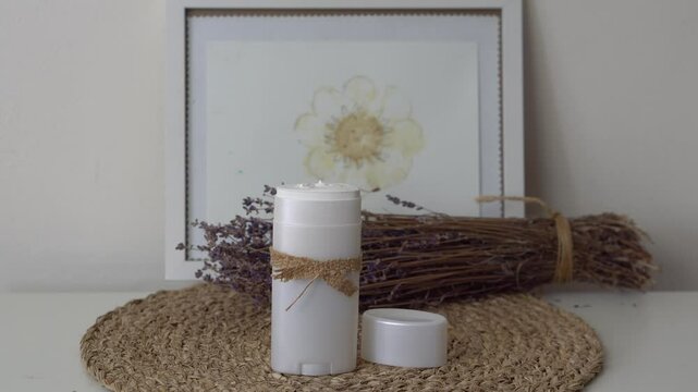 Homemade natural SPF stick with zinc oxide on white and beige background. Organic sun protection balm with dry lavender flower. Zero waste skincare. DIY sunscreen for summer skincare.
