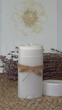 Homemade natural SPF stick with zinc oxide on white and beige background. Organic sun protection balm with dry lavender flower. Zero waste skincare. DIY sunscreen for summer skincare.