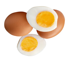 Top view of two raw chicken eggs and peeled cooked or boiled egg with egg yolk in two halves in stack isolated on white background with clipping path