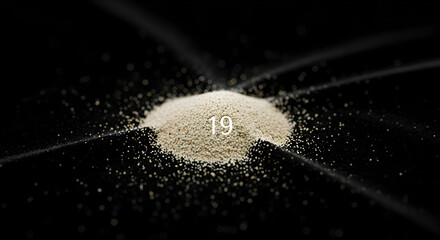Heap Of Powder On Black Surface With Number Nineteen Overlay