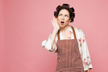 Young sad housewife housekeeper chef cook baker woman wear brown apron try to hear you overhear...
