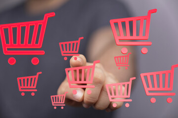 Person using touchscreen, selecting virtual shopping carts.  E-commerce, online retail concept.