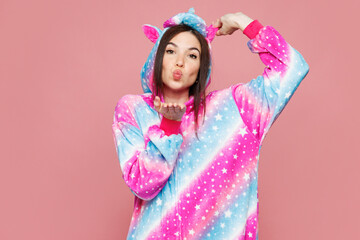 Young happy cute fun woman she wear domestic costume with hoody hold animal ears blow send air kiss look camera isolated on plain pastel light pink wall background studio portrait. Lifestyle concept.