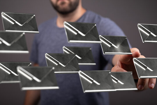 Stock photo of a man interacting with a digital interface showing multiple email icons.