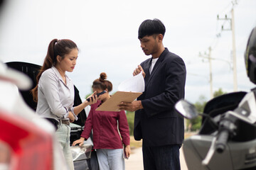 Fototapeta premium Frustrated driver and insurance company representative argue next to damaged car. Agent examines bumper, writes report, offers assistance, repair advice, and supports claim.