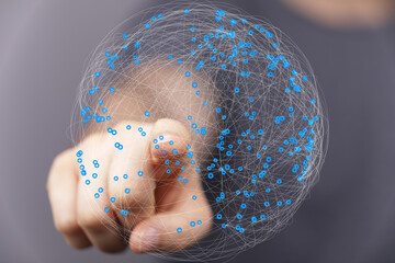 Abstract image of a hand interacting with a digital global network.  Represents connection,...