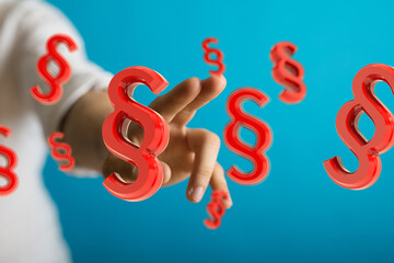 Abstract image of a hand and floating red paragraph symbols.  Ideal for legal, law, and regulation...