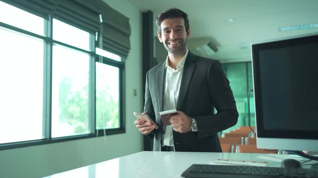 Good looking and smart Asian businessman smiles to camera while check-in at the international airport.	