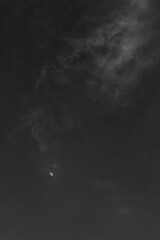 Moon shines through black and white abstract clouds