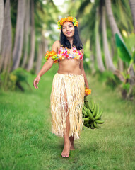 Ethnic woman dressed as Hawaii Hula Dancer, carrying bananas in tropical nature