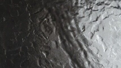 Textured Grey Surface: Close-up view of a rough, textured surface in varying shades of grey, with rugged, uneven patterns and visual depth. A neutral and versatile background.