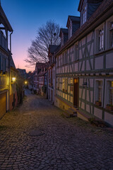A small alley with lanterns and half-timbered houses at dusk in Idstein in the Taunus region