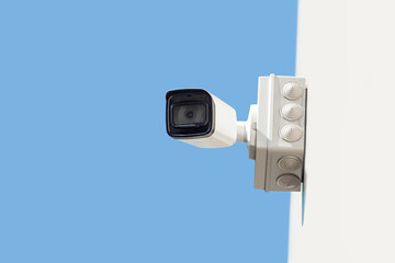 Outdoor Security Camera on White Wall Against Blue Sky