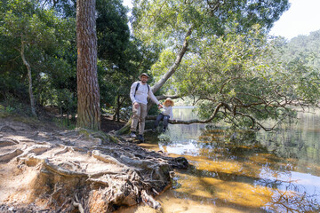 Father and son exploring nature by the lake on a sunny day