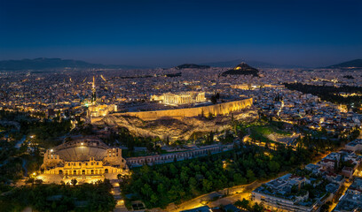 Aerial view of the illuminated Parthenon Temple and the Odeon of Herode theatre at the Acropolis of Athens, Greece, during night time