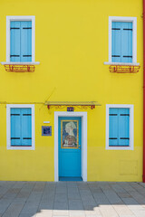Yellow houses with blue cloused shutters on Burano Island Venice Italia