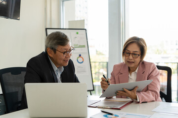 Senior businessmen analyzing data together.