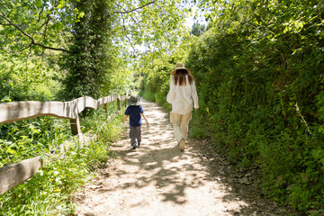 Fototapeta premium Mother and son walking on a path in the woods