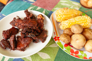 Fritada artesanal de cerdo con choclo y papas hervidas, plato típico de la región andina del Ecuador.