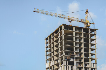 Construction Crane on High-Rise Building Under Blue Sky